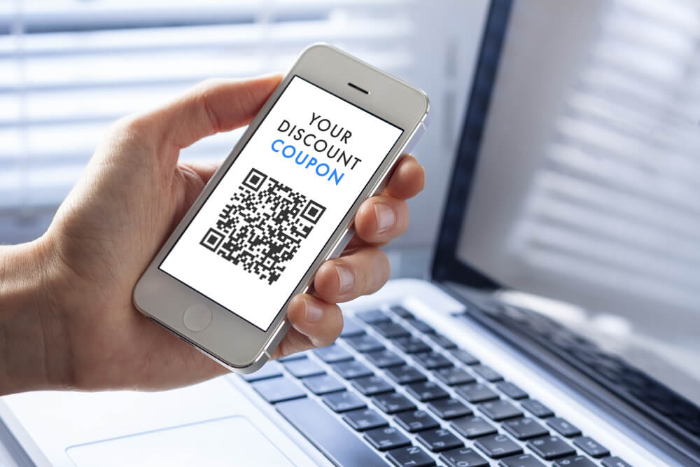 携帯でクーポンなどを利用してマーケティングをする様子